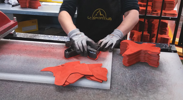 Cutting leather pieces for climbing shoes.
